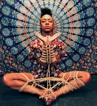 a woman sitting in front of a mandala